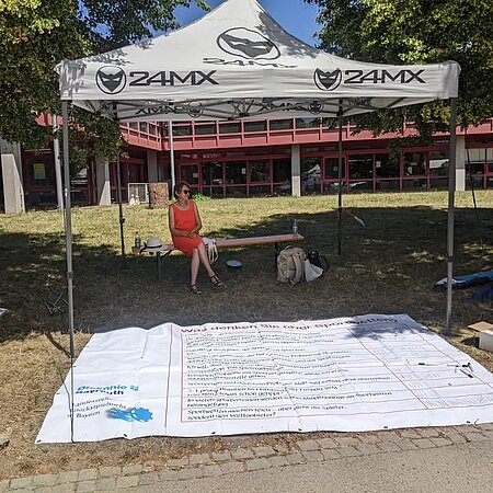 Trotz 34 Grad: Glücksspielprävention erreicht Studierende in Bayreuth

Am vergangenen Donnerstag war unsere Kollegin Gunhild Scheidler von der Fachstelle Glücksspielsucht beim Gesundheitstag der Uni Bayreuth im Einsatz – und das bei hochsommerlichen 34 Grad im Schatten!

Trotz der Konkurrenz durch das nahegelegene Freibad war das Interesse groß:
- rund 190 Markierungen auf unserer interaktiven Bodenplane
- über 60 Studierende setzten sich aktiv mit dem Thema Glücksspiel auseinander
- viele persönliche Gespräche und Fragen rund um Glücksspiel und Glücksspielsucht

Besonders eindrücklich:
24 Studierende bestätigten die Aussage „Ich kenne jemanden, der ein echtes Problem mit Sportwetten hat.“

Ein starkes Zeichen dafür, wie präsent das Thema auch im studentischen Alltag ist.

Danke, liebe Gunhild, für deinen Einsatz und dafür, dass du das Thema Glücksspiel(sucht) erneut sichtbarer gemacht hast – selbst bei diesen tropischen Temperaturen.

#Glücksspielsucht #Prävention #Gesundheitstag #UniBayreuth #Aufklärung #Suchtprävention