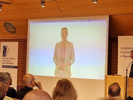Das war der 16. Bayerische Fachkongress Glücksspiel. 
76 Teilnehmende vor Ort und 94 online folgten dem spannenden Programm beginnend mit Grußworten der bayerischen Gesundheitsministerin Judith Gerlach und Konrad Landgraf, Geschäftsführer der Landesstelle Glücksspielsucht in Bayern. 
Mit den ersten beiden Vorträgen über "Neobroker und Online Trading" und "Glücksspielwerbung im deutschen Profifußball" wurden hochaktuelle Themen behandelt. Bei der anschließenden  Podiumsdiskussion "Was bleibt nach dem Abpfiff? Perspektiven auf den Umgang mit Sportwetten und Sportwettenwerbung" wurde kontrovers diskutiert und neben unterschiedlichen Perspektiven und Meinungen kamen auch belegbare Fakten nicht zu kurz. Auf dem Podium standen der bekannte Podcaster Basti Red, CSU Landtagsabgeordnete Petra Guttenberger, Konrad Landgraf (LSG), Dr. Johannes Singer von der Forschungsstelle Glücksspiel der Universität Hohenheim und Markus Sotirianos vom Bündnis gegen Sportwetten-Werbung. 
Am Nachmittag teilten sich die rund 170 Teilnehmenden auf in Workshops zu den Themen Deeskalation, Motivation und Krankheitseinsicht, Gruppenarbeit, Recovery und Resilienz für Helfende.      
In Fragerunden, Workshops und zwischen den Programmpunkten gab es einen angeregten Austausch zwischen den Teilnehmenden aus Suchtberatung und -therapie, Selbsthilfe und Betroffenenbeirat, Kliniken, Schuldnerberatung, betrieblicher Sozialarbeit, anderen sozialen Einrichtungen, von Ministerien und Glücksspielanbietern. 
Dank an alle Vortragende, Moderierende, Mitgestaltende und Teilnehmende für diesen gelungenen Tag.